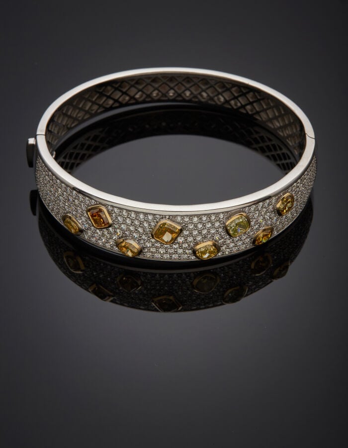 BRACELET rigide ouvrant en or gris et or jaune (750‰) pavé de diamants taille b…