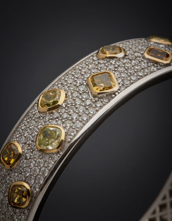 BRACELET rigide ouvrant en or gris et or jaune (750‰) pavé de diamants taille b…