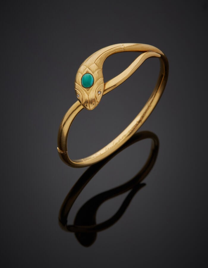 BRACELET « serpent » rigide ouvrant en or jaune (750‰) la tête ciselée, ornée d…
