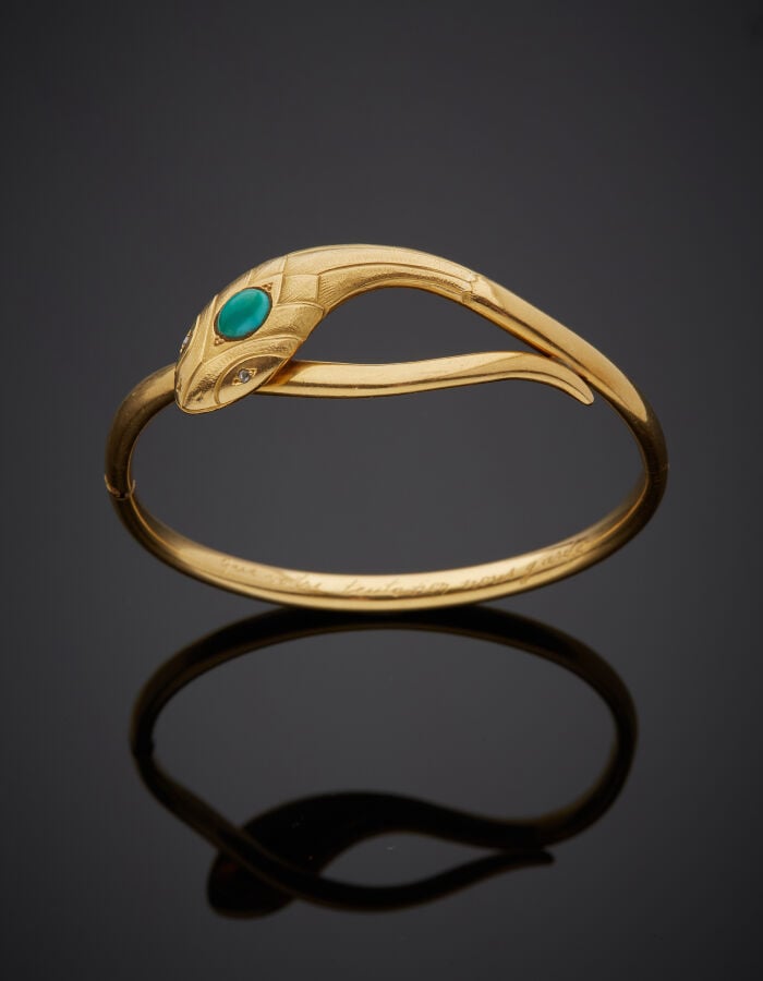 BRACELET « serpent » rigide ouvrant en or jaune (750‰) la tête ciselée, ornée d…