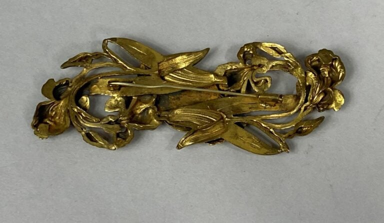 Broche en métal doré ajouré à décor de médaillon avec profil de femme et motifs…