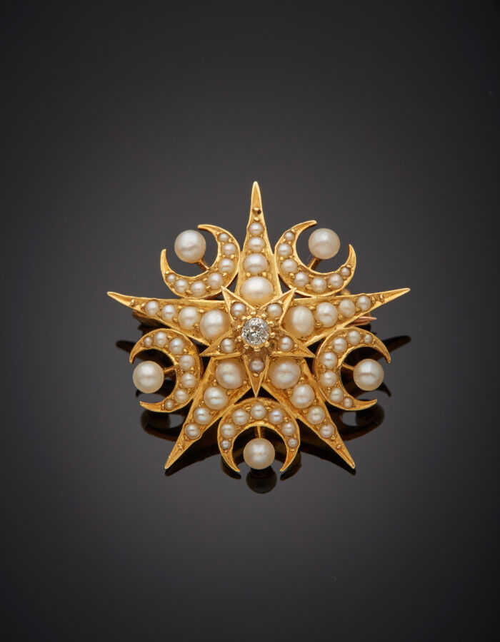 BROCHE "étoile et croissants de lune" en or jaune (750‰) ajouré, orné de perles…