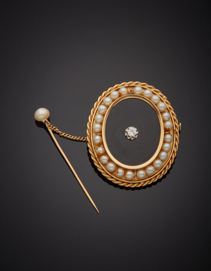 BROCHE ovale en platine (min. 800‰) et or jaune (750‰) orné d'une plaque d'onyx…