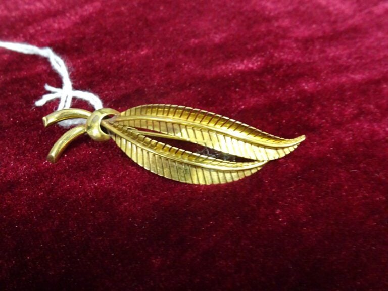 Broche "Palme" en or jaune 750 millièmes (tête d'aigle). - Poids net: 6,4 g.