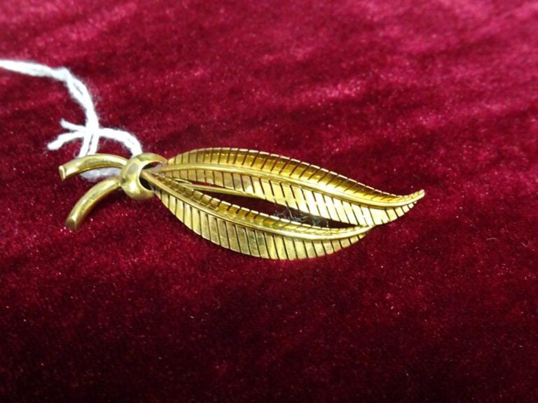 Broche "Palme" en or jaune 750 millièmes (tête d'aigle). - Poids net: 6,4 g.