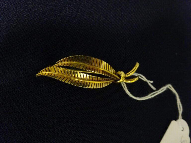 Broche "Palme" en or jaune 750 millièmes (tête d'aigle). - Poids net: 6,4 g.