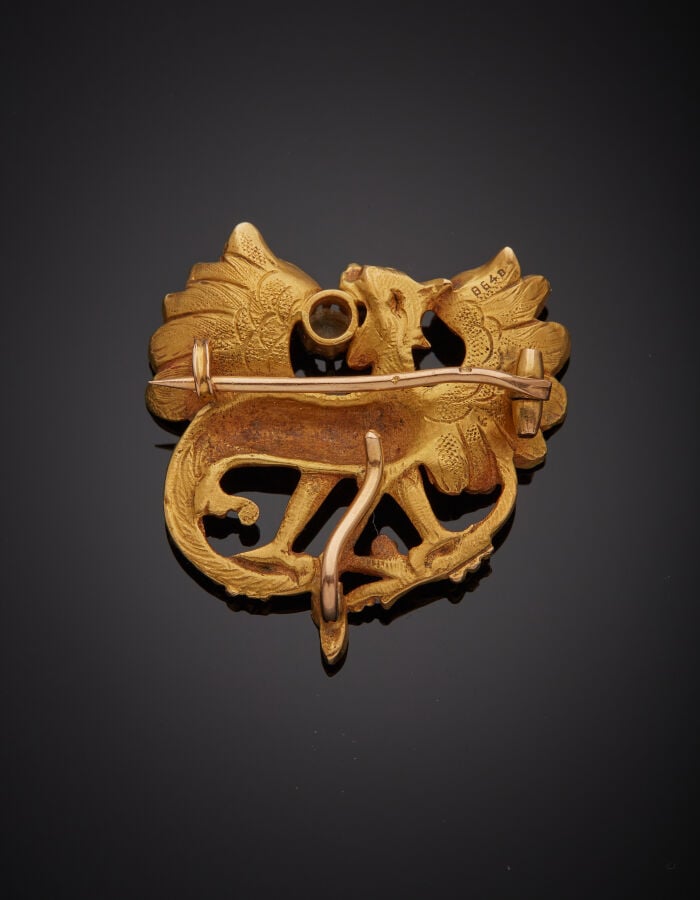 BROCHE-PENDENTIF "dragon ailé" en or jaune (750‰) sculpté et ciselé, serti d'un…