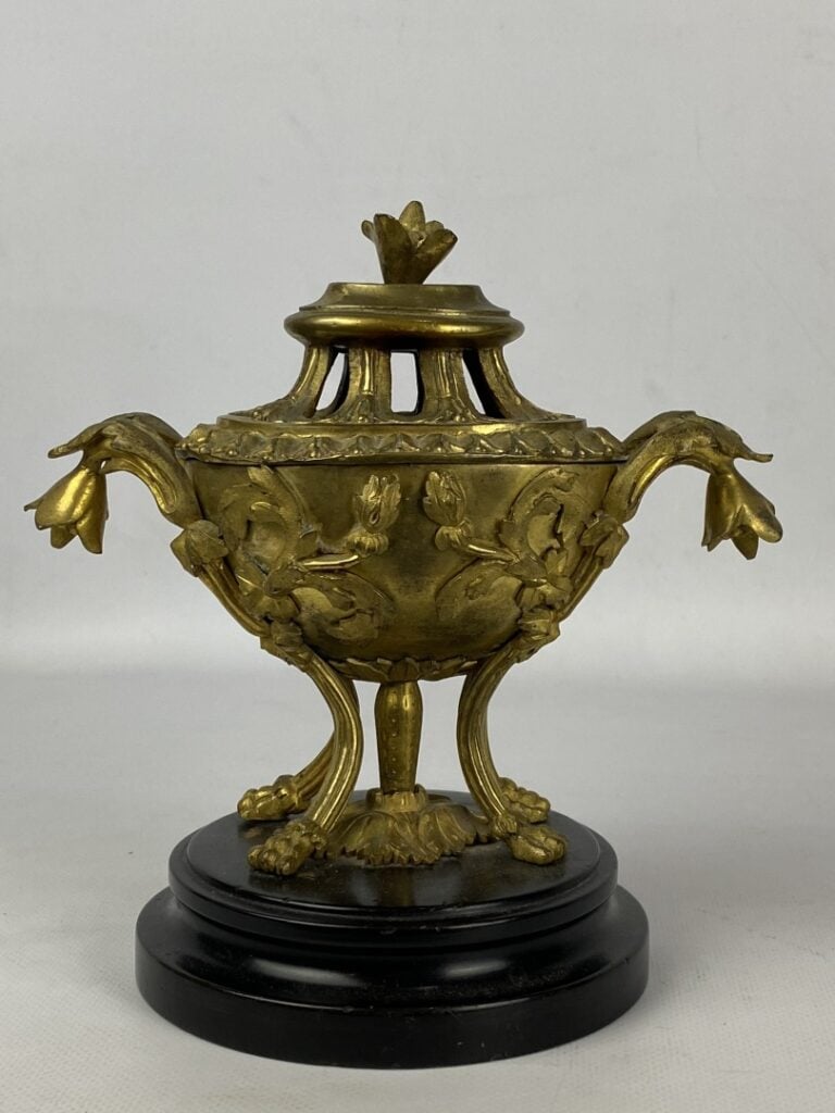 Brûle-parfum quadripode en bronze doré orné en relief de fleurs et feuillages.…