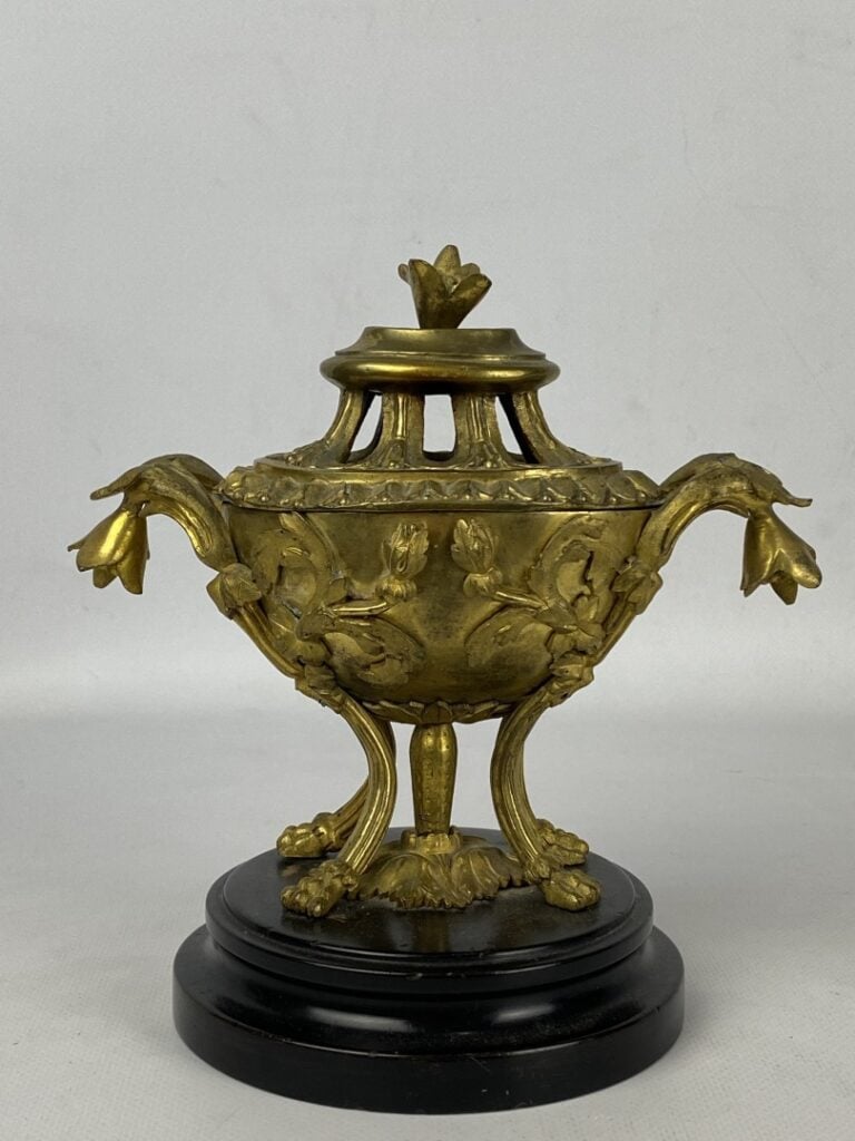 Brûle-parfum quadripode en bronze doré orné en relief de fleurs et feuillages.…