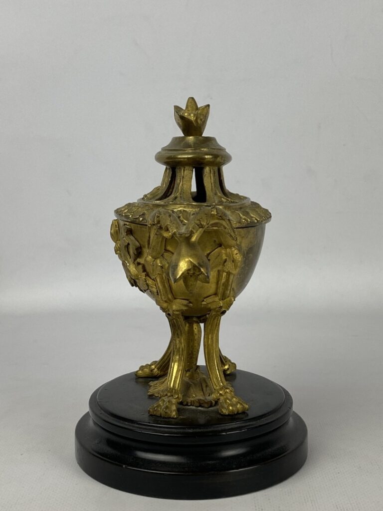 Brûle-parfum quadripode en bronze doré orné en relief de fleurs et feuillages.…