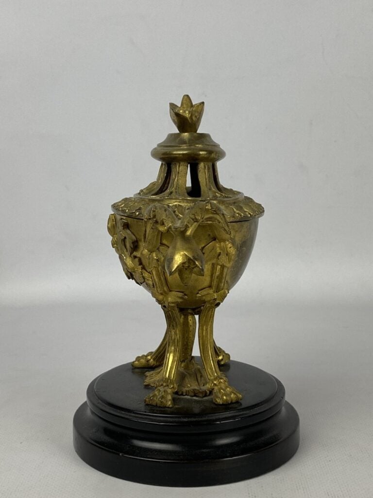 Brûle-parfum quadripode en bronze doré orné en relief de fleurs et feuillages.…