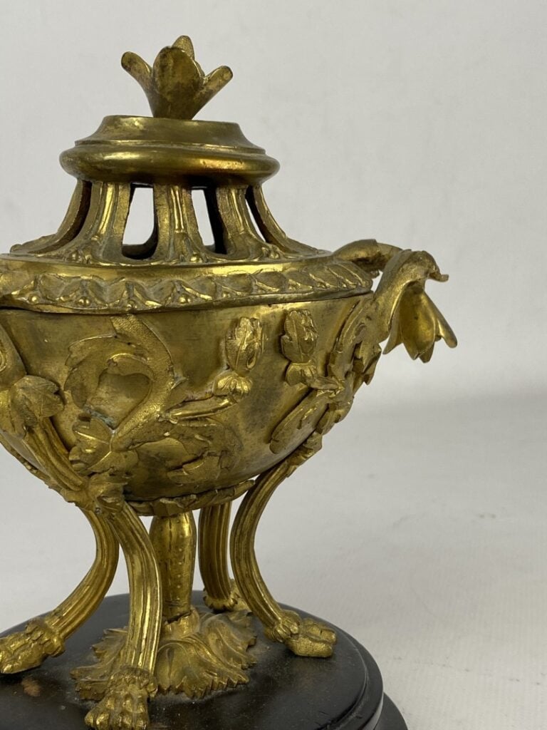 Brûle-parfum quadripode en bronze doré orné en relief de fleurs et feuillages.…