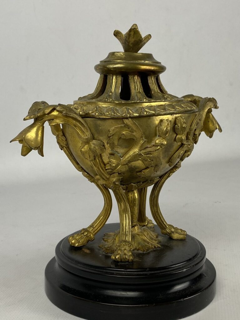Brûle-parfum quadripode en bronze doré orné en relief de fleurs et feuillages.…