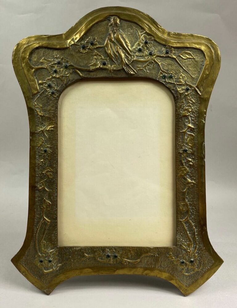 Cadre photo de forme mouvementée en bois et plaque de laiton repoussé à décor d…