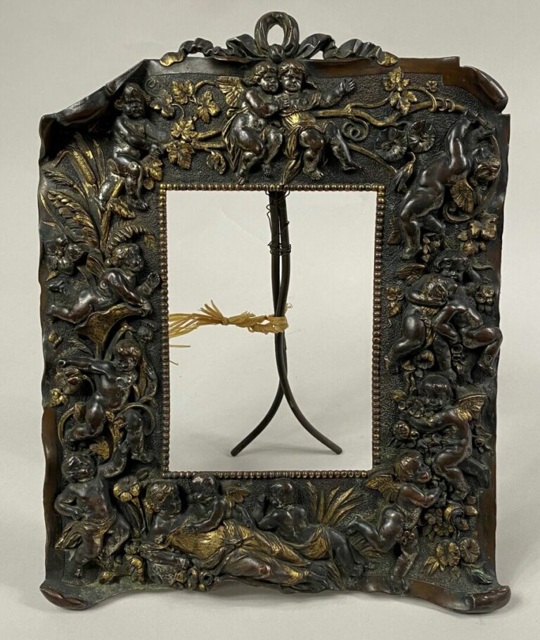 Cadre-photo en métal doré à décor en relief de putti, pampres de vigne et guirl…