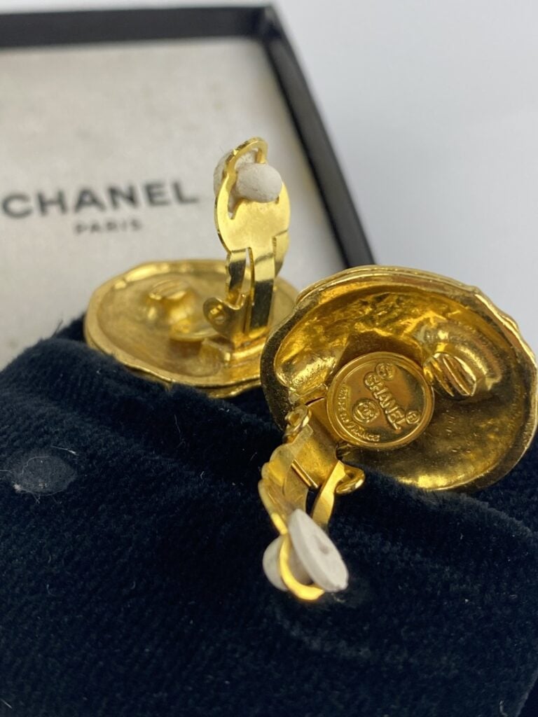 CHANEL - Paire de clips d'oreilles en métal doré légèrement martelé ornés du si…