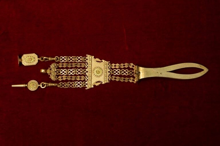 Chatelaine en or 750 millièmes, orné de breloques. - Poids: 33 g.