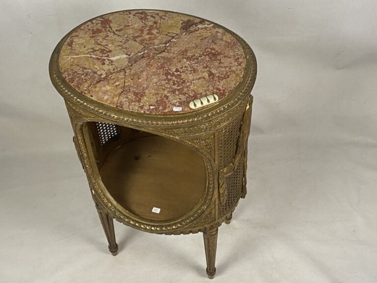 Chevet de forme tambour en bois doré sculpté à décor de frises de piastres enfi…