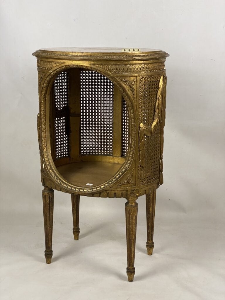 Chevet de forme tambour en bois doré sculpté à décor de frises de piastres enfi…