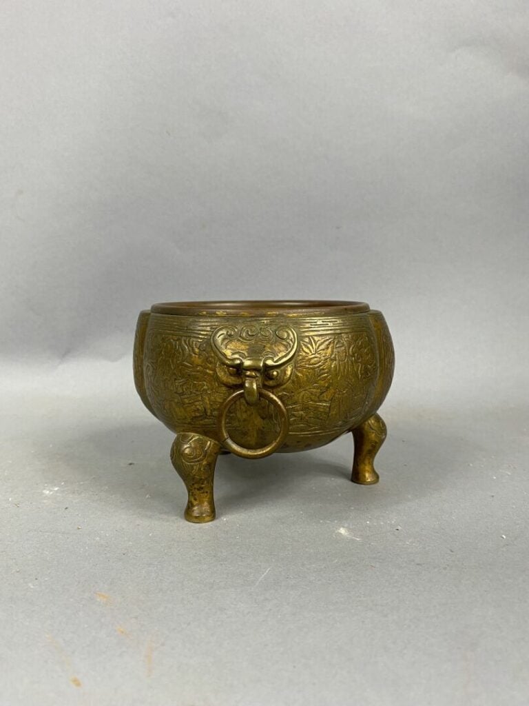 CHINE - Brûle-parfum en bronze doré tripode à décor de scènes animées sur le po…