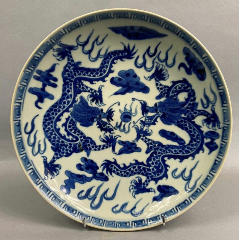 CHINE - Plat en porcelaine bleu blanc à décor de deux dragons s'affrontant pour…