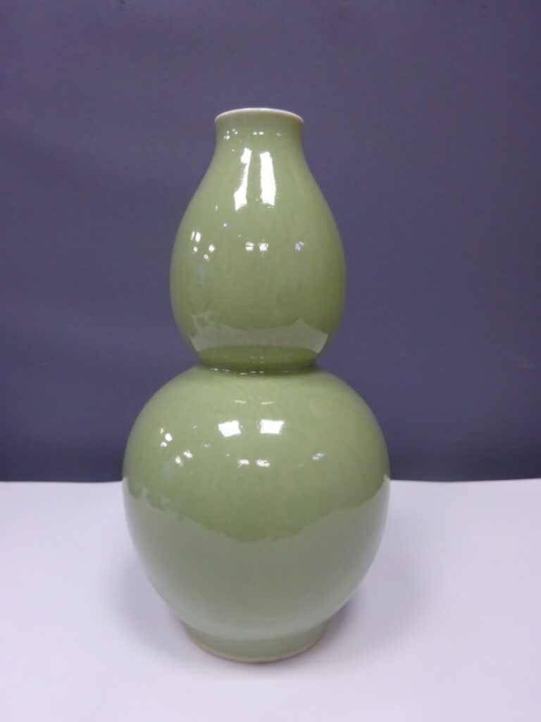 CHINE - Vase de forme coloquinte en porcelaine à couverte céladon. Incisé d'un…