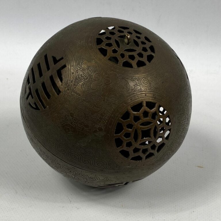 CHINE, XXe siècle - Sphère ajourée en bronze à patine brune, ouvrant en son cen…