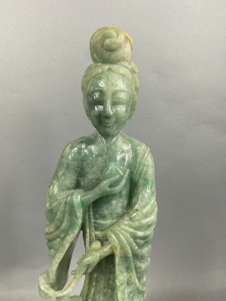 CHINE, XXème - Geisha en jade sculpté tenant une pêche de longévité dans la mai…