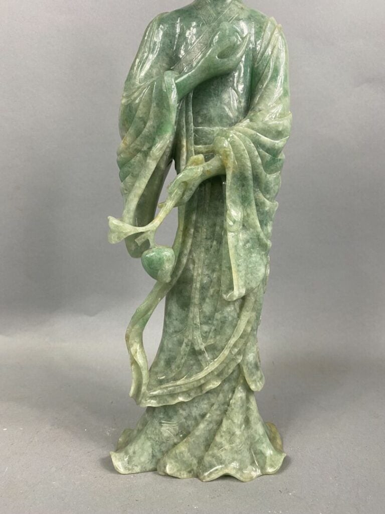 CHINE, XXème - Geisha en jade sculpté tenant une pêche de longévité dans la mai…