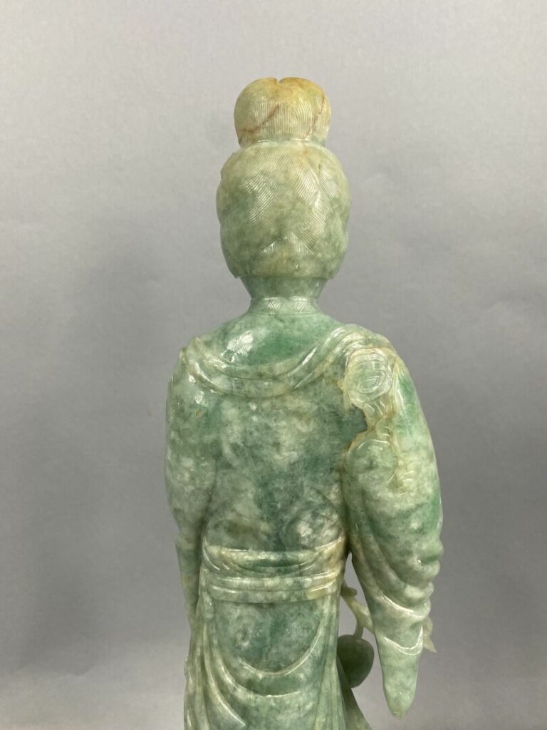 CHINE, XXème - Geisha en jade sculpté tenant une pêche de longévité dans la mai…
