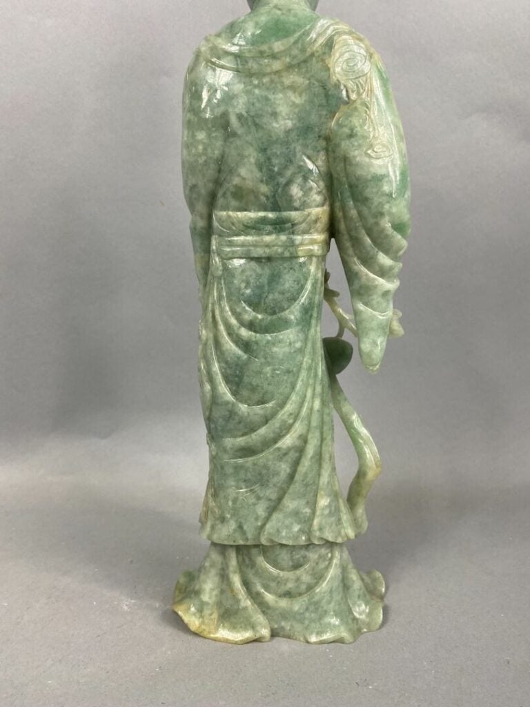 CHINE, XXème - Geisha en jade sculpté tenant une pêche de longévité dans la mai…