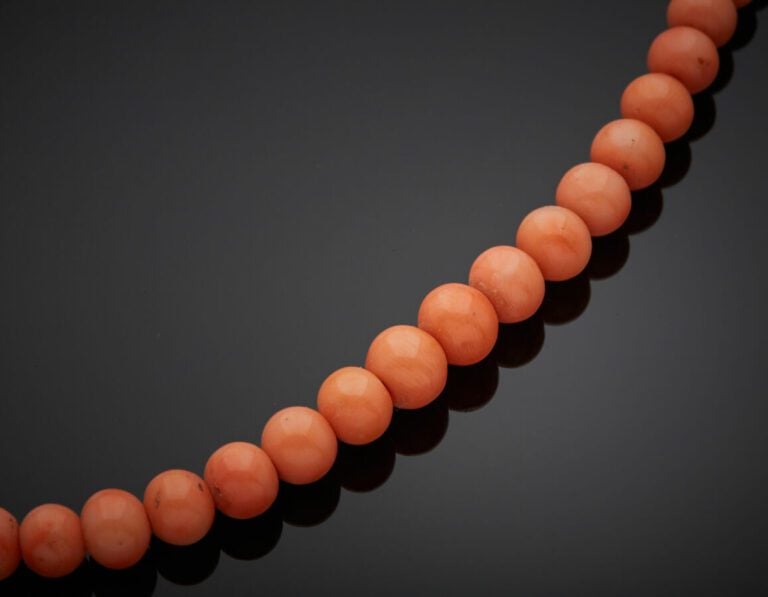 COLLIER composé d'un rang de perles de corail en chute. Fermoir perle en or jau…