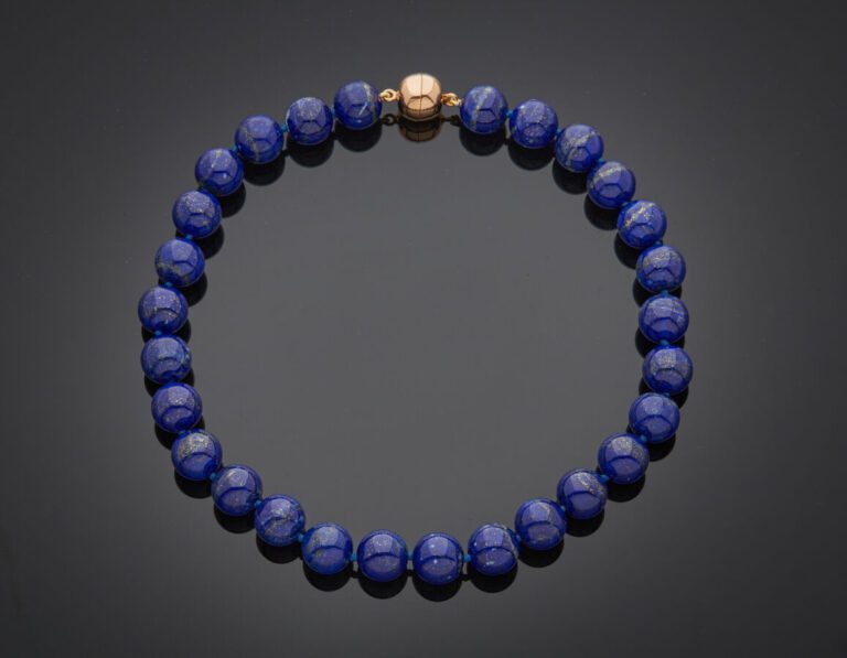 COLLIER composé d'un rang de perles de lapis lazuli. Fermoir "boule" aimanté en…