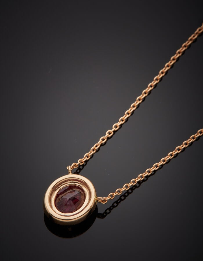 COLLIER en or rose (750‰) retenant un motif ovale, serti d'un rubis pesant 3,29…