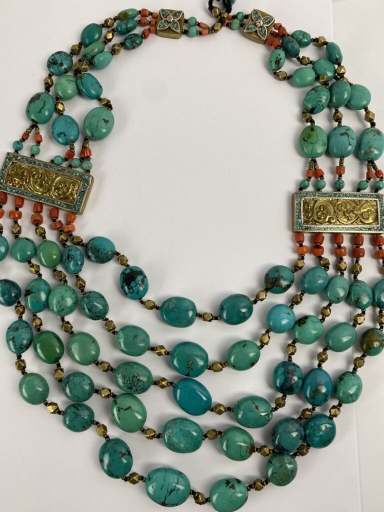 Collier plastron formé de cinq rangs de perles de turquoise, orné de plaques re…