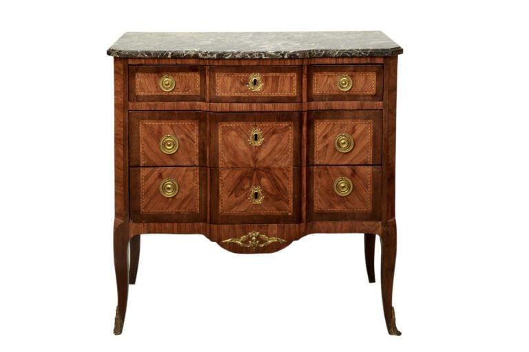 Commode en bois de placage, la façade à ressaut ouvrant par trois tiroirs dont…