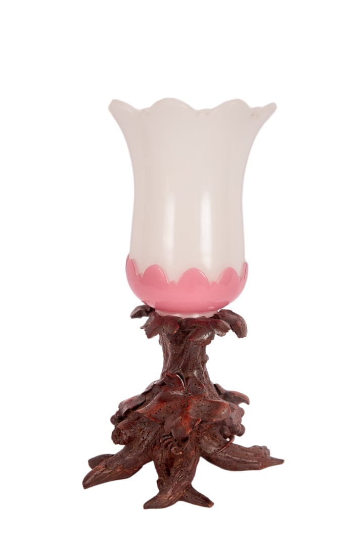 Coupe de forme tulipe en verre opalin blanc et rose posant sur un socle en bois…