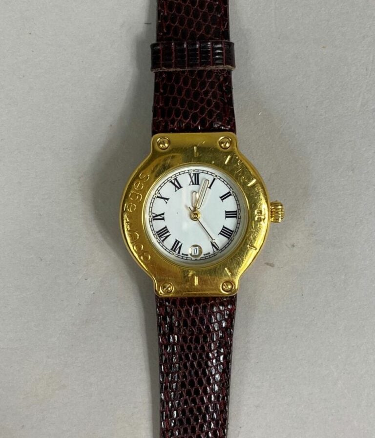 COURREGES - Montre bracelet de dame, boitier en métal doré, lunette graduée et…