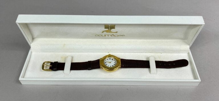 COURREGES - Montre bracelet de dame, boitier en métal doré, lunette graduée et…