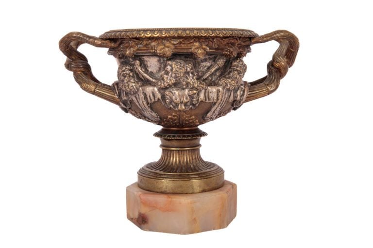 Cratère sur piédouche cannelé en bronze patiné, le corps orné d'une frise de bu…