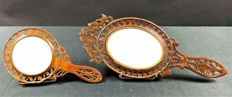 Deux miroirs face à main à monture ajourée, l'un ovale, l'autre rond, en marque…