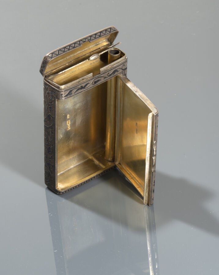 Etui à cigarettes en argent amati à décor de rinceaux. - Il contient un briquet…