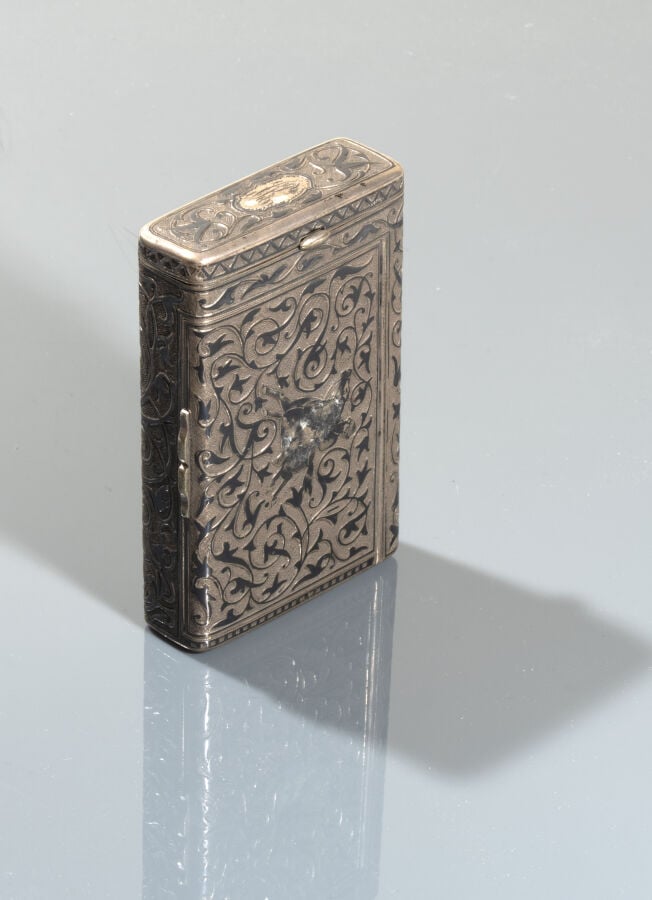 Etui à cigarettes en argent amati à décor de rinceaux. - Il contient un briquet…