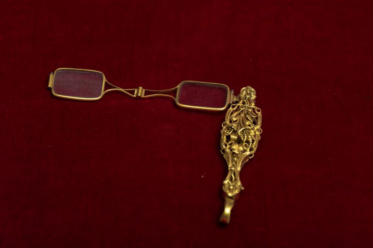 Face à main abritant des lunettes dépliantes en or 750 millièmes. - Poids: 25 g…