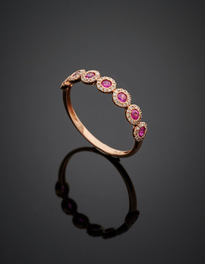 Fine BAGUE en or rose (750‰) serti de sept rubis ronds, chacun entouré de petit…