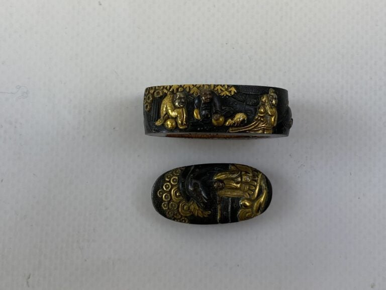 FUCHI KASHIRA EN FER REHAUSSE D'OR - Japon - Au décor de personnages dont un pê…