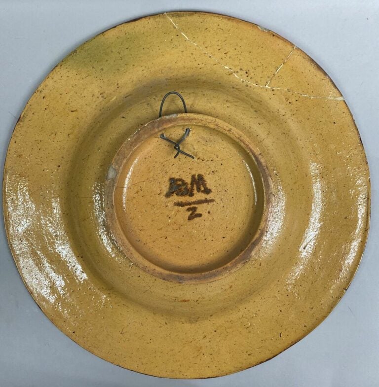 Grand plat rond en céramique émaillée orné d'une scène en léger relief représen…