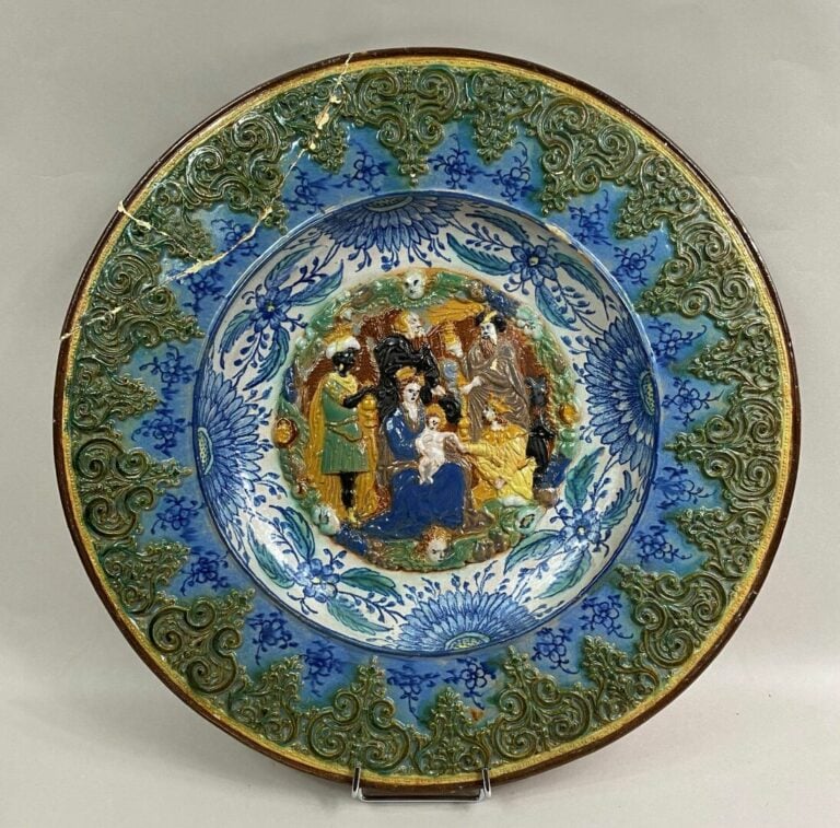 Grand plat rond en céramique émaillée orné d'une scène en léger relief représen…