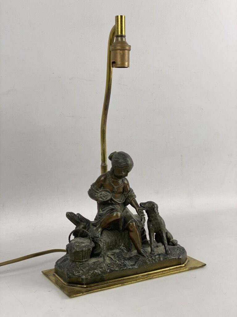 Groupe sculpté en régule patiné figurant un enfant donnant à manger à son chien…