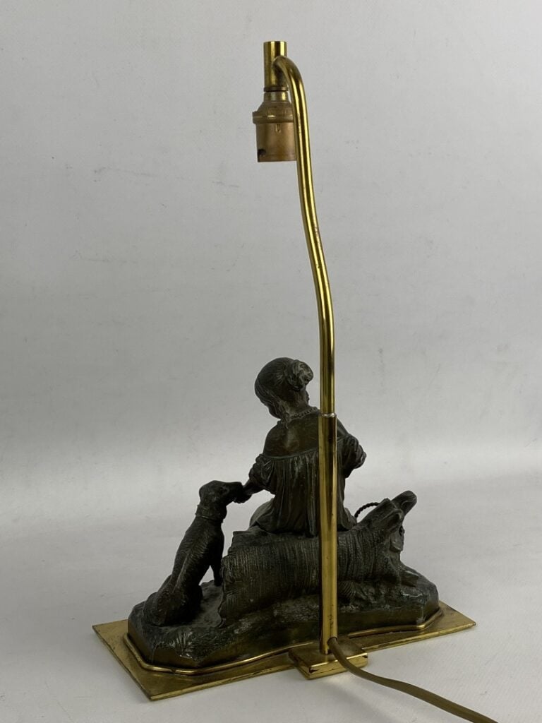 Groupe sculpté en régule patiné figurant un enfant donnant à manger à son chien…